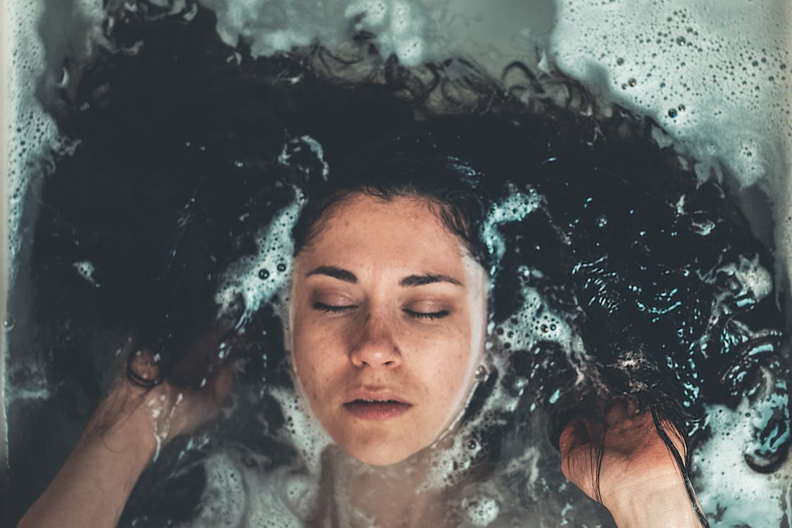 Woman taking a relaxing bubble bath.