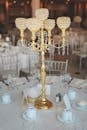 宴会厅精致的餐桌上，优雅的金色枝形烛台是中心装饰品