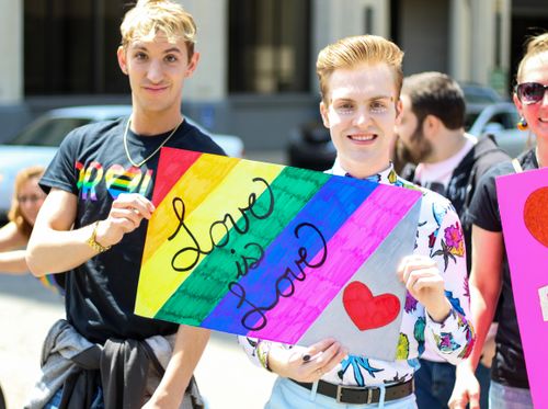 Free LGBTQ pride parade with colorful signs and joyful participants celebrating love and diversity. Stock Photo