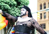 一个穿着充满活力的服装、妆容亮丽的人在户外骄傲活动中庆祝多样性