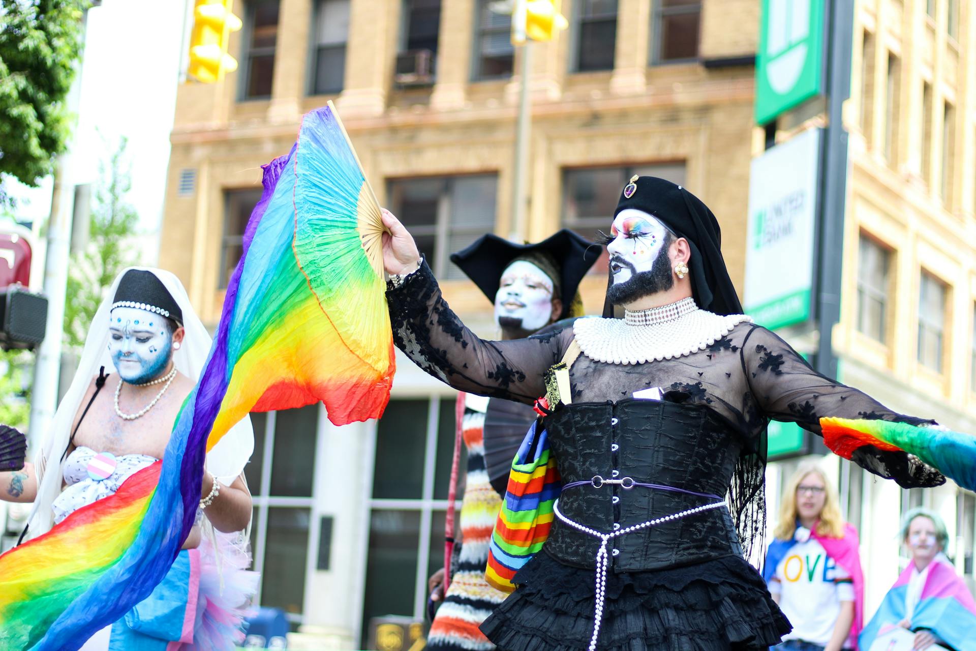 People Holding Rainbow Hand Fans