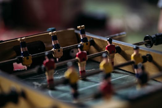 Close-up of a foosball table with miniature soccer players in action.