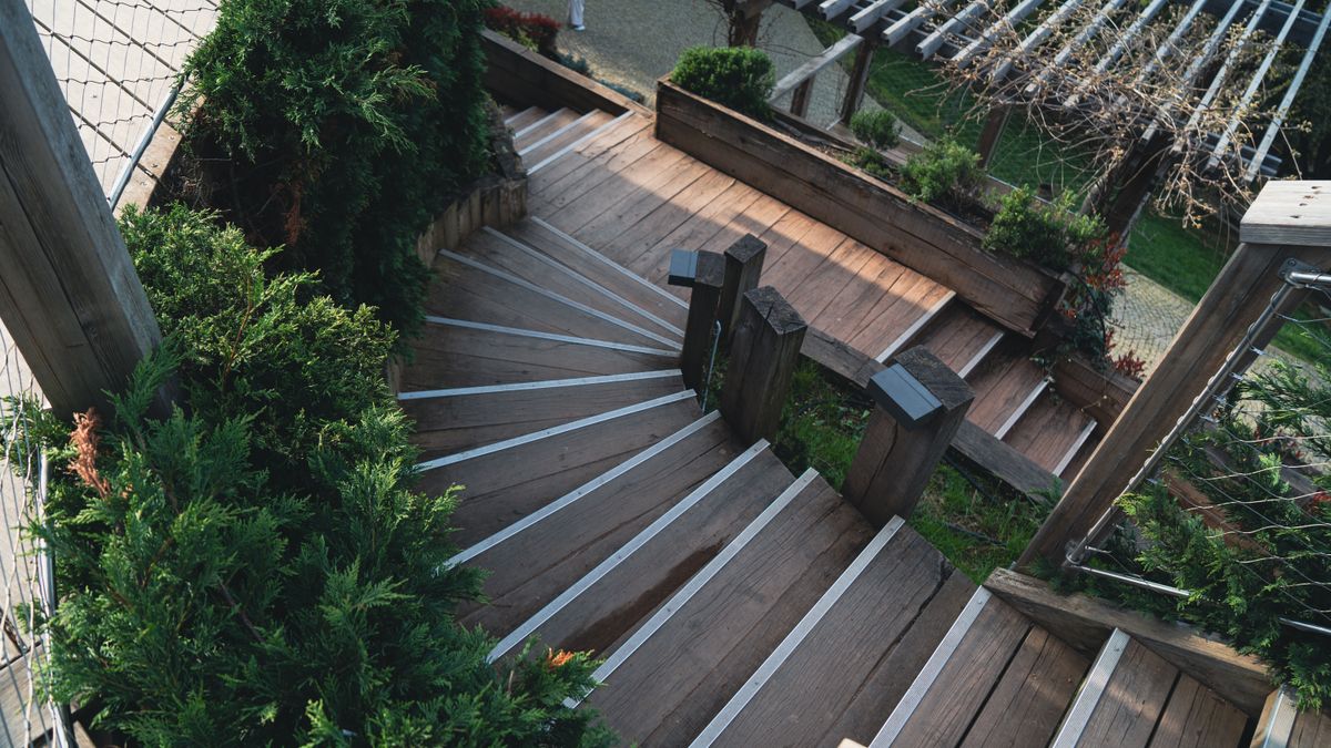 An outdoor wooden staircase with railings on both sides.