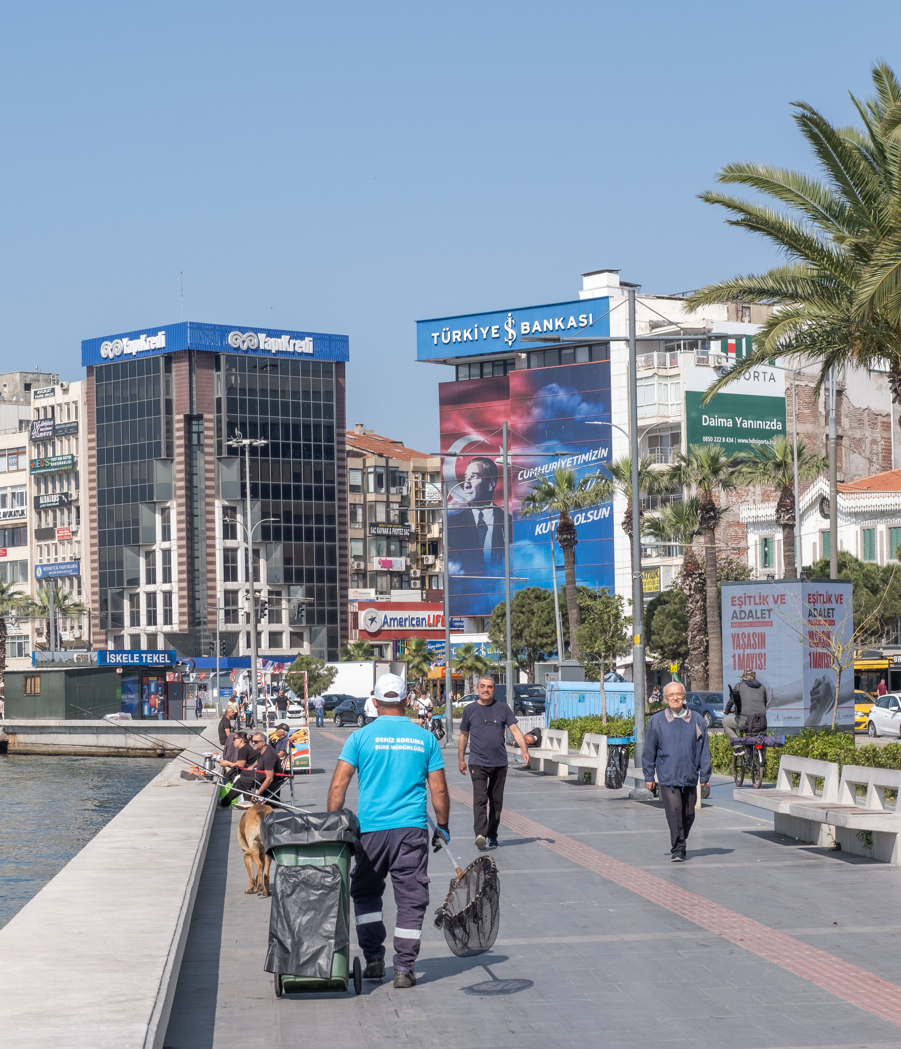 A bustling scene on the Konak promenade in İzmir, Turkey with people walking and modern buildings in the background.