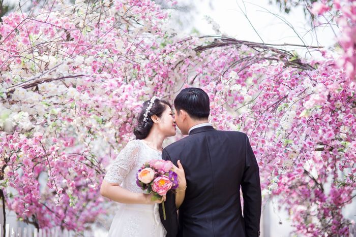 Wedding couple sharing a tender kiss in a lush green forest