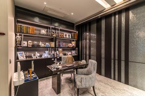 A home office with a desk, bookshelves and a chair