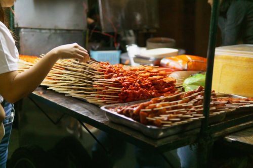 Free A woman preparing a variety of skewers at a street food stall in Calabarzon, Philippines. Stock Photo