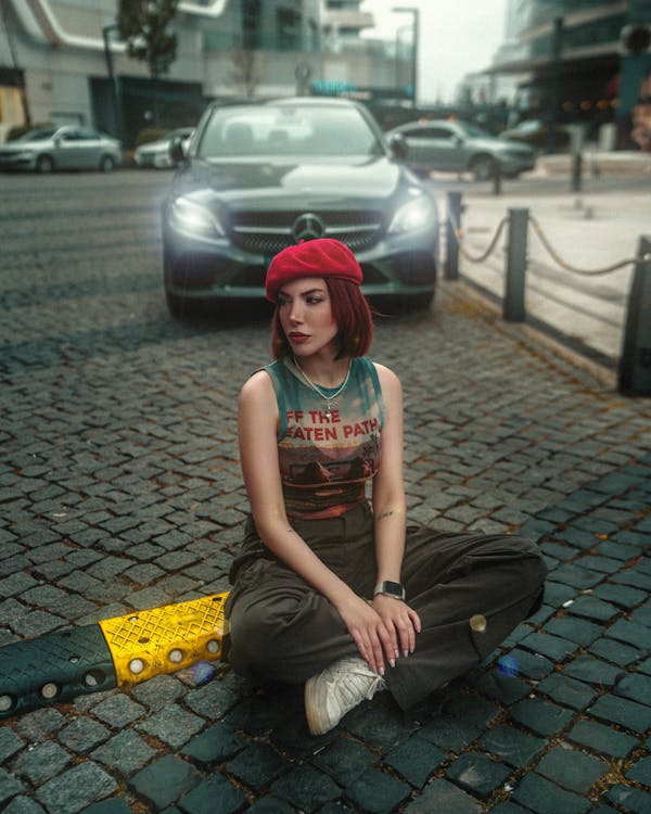 A woman sitting on the ground with her skateboard
