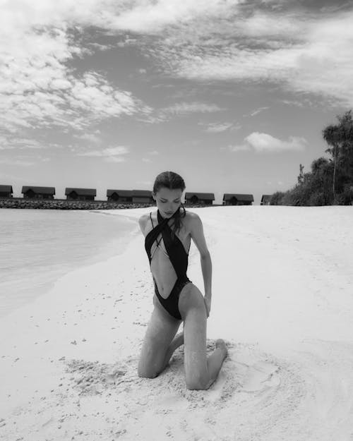 A woman in a black and white swimsuit on the beach