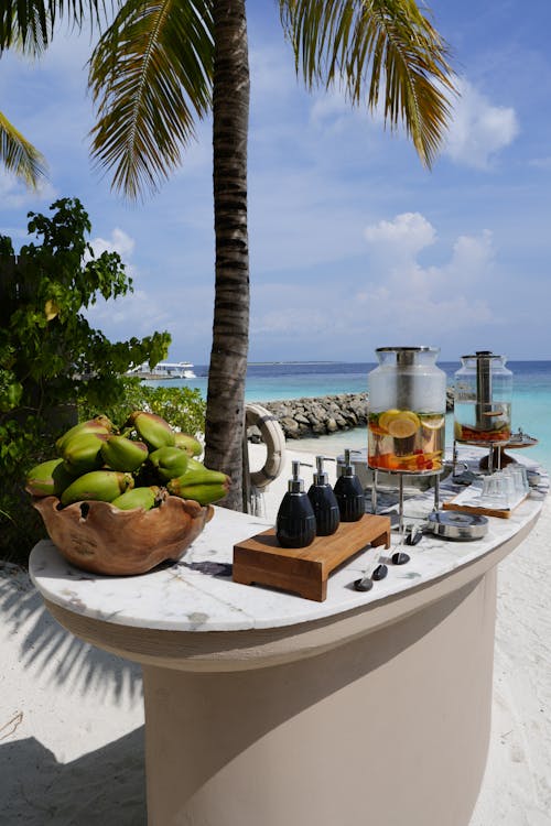A buffet with fruit and drinks on the beach