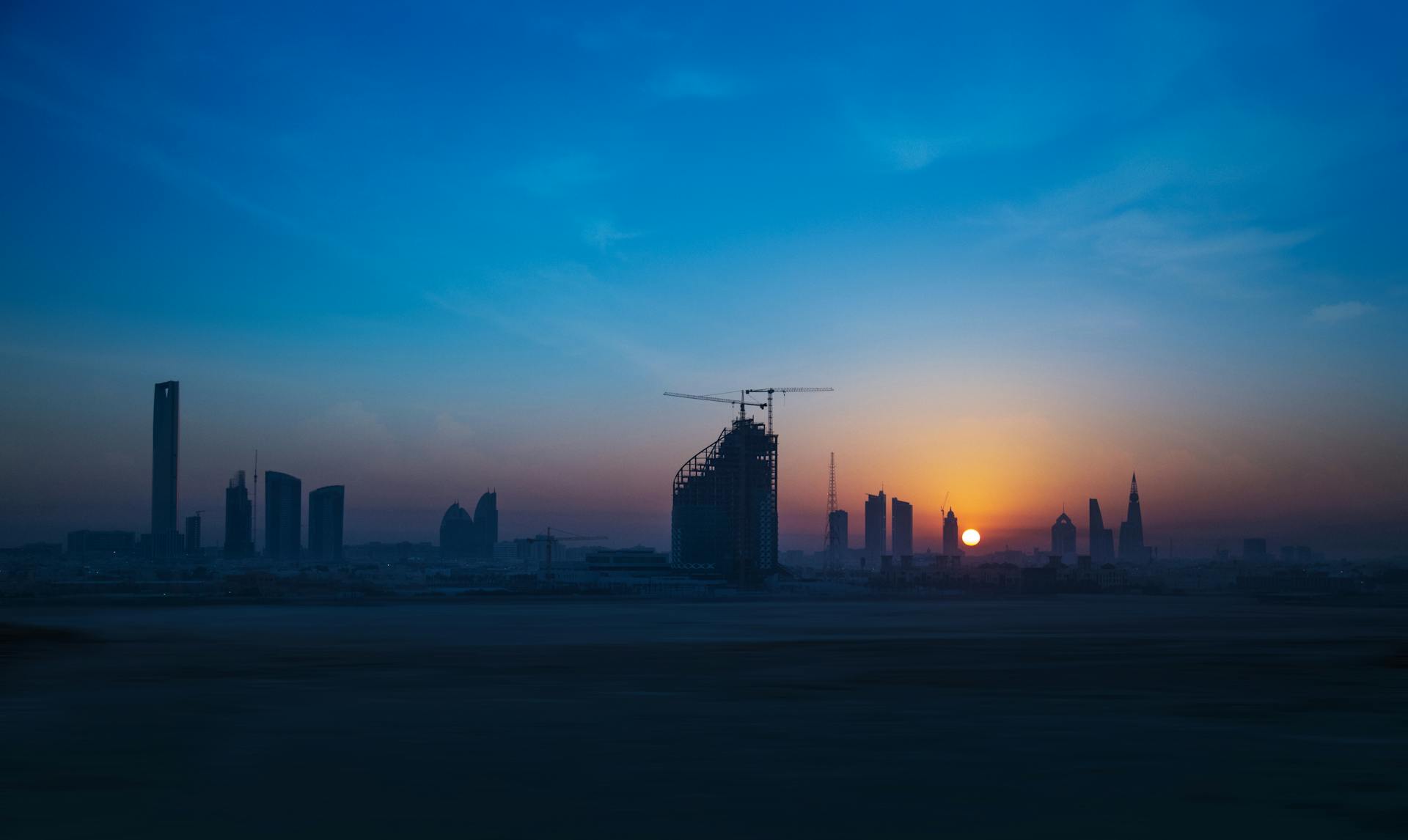 Captivating view of a city skyline with construction cranes at sunset, perfect for urban themes.