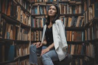 在堆满书的哈萨克斯坦图书馆里，一名年轻女子若有所思地坐着