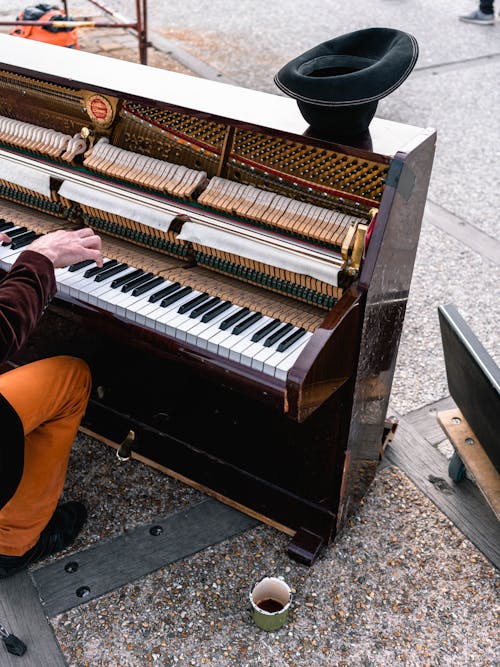 бесплатная Человек играет коричневое пианино в вертикальном положении Стоковое фото