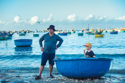 A man and child in a blue boat on the water