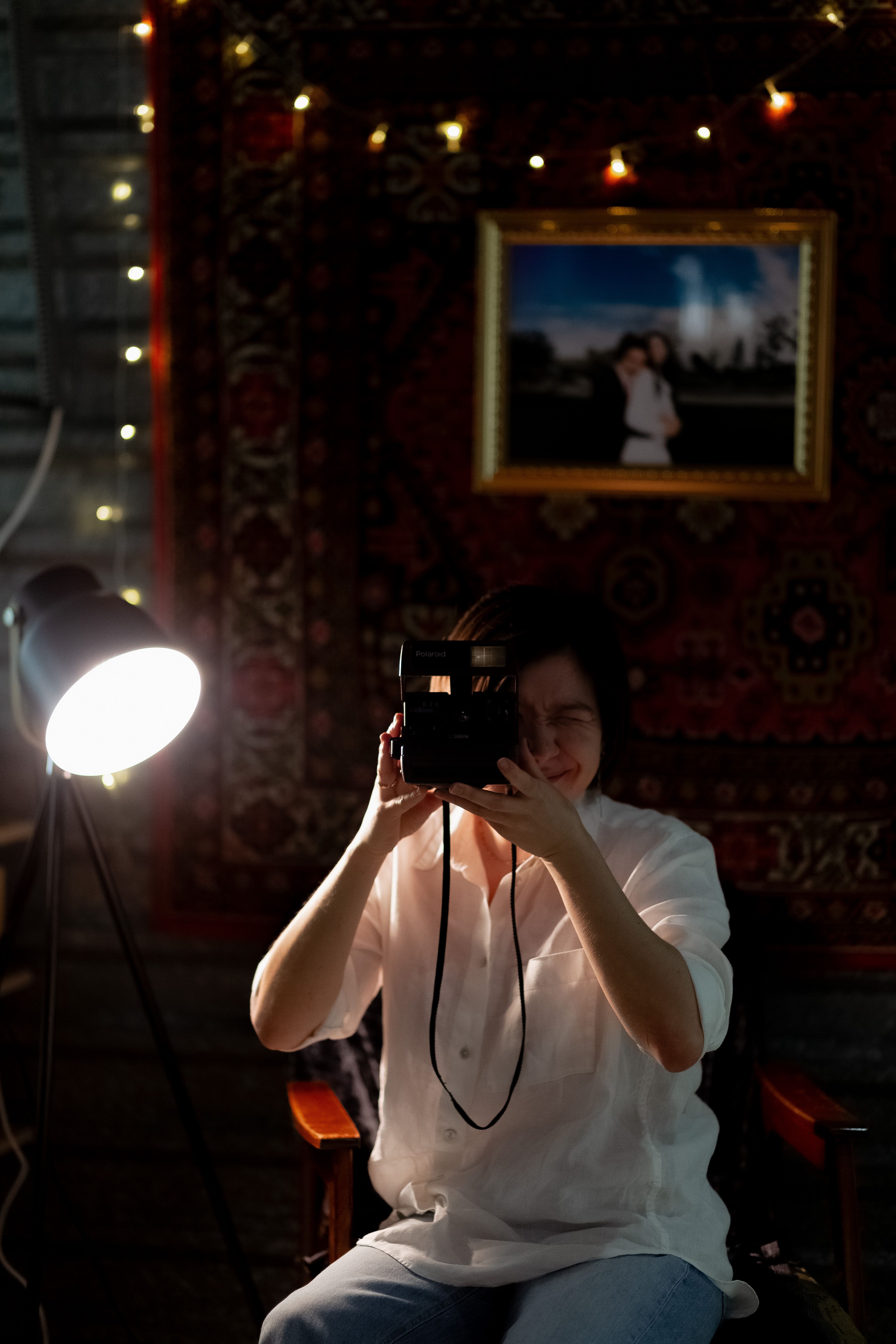 A Woman Sitting in a Dark Room and Holding a Vintage Camera · Free ...