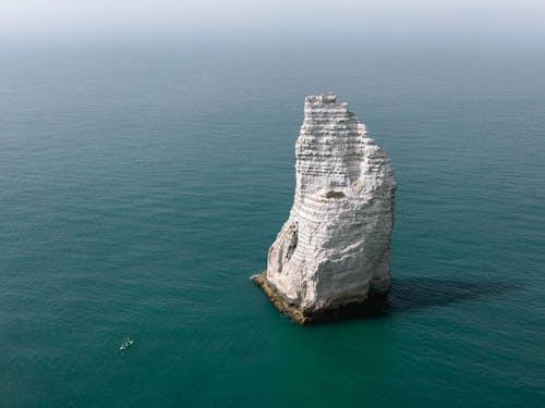 무료 바다 한가운데에있는 백색 암석 스톡 사진