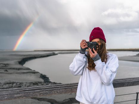 Photo of Smiling Woman Taking a Photo During Gloomy Day