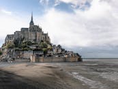 圣米歇尔山的标志性建筑在多云天空的映衬下，展现出令人惊叹的景观