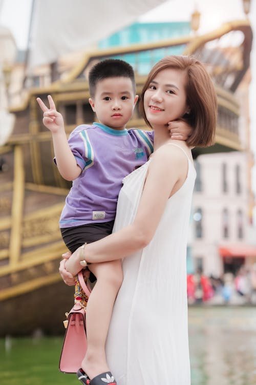 A woman and her son pose for a photo in front of a boat
