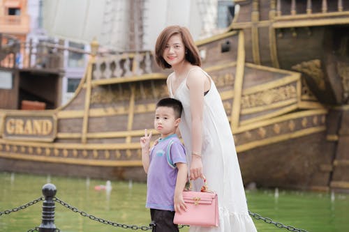 A woman and child posing for a picture in front of a ship