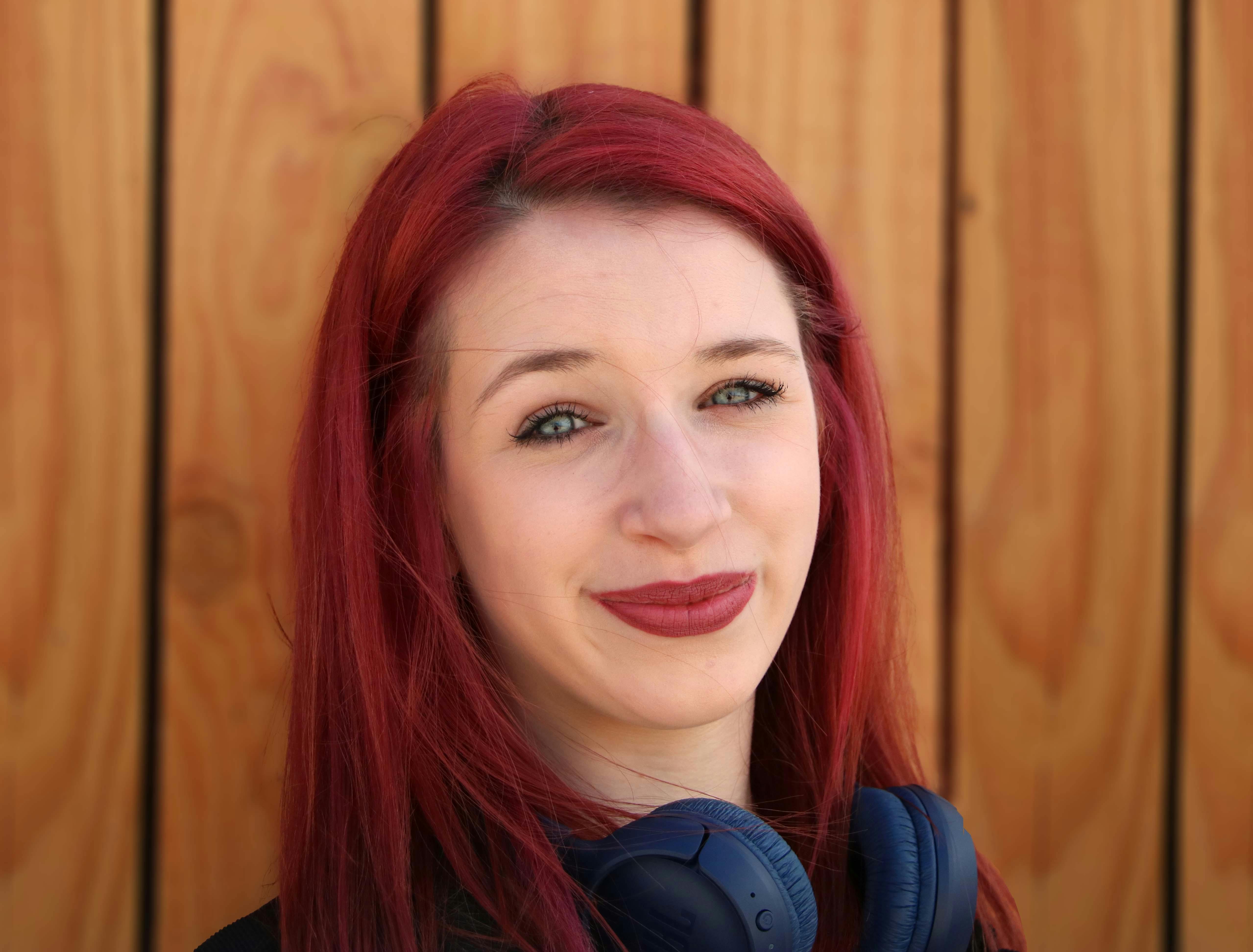 portrait of a smiling girl with red hair and headphones