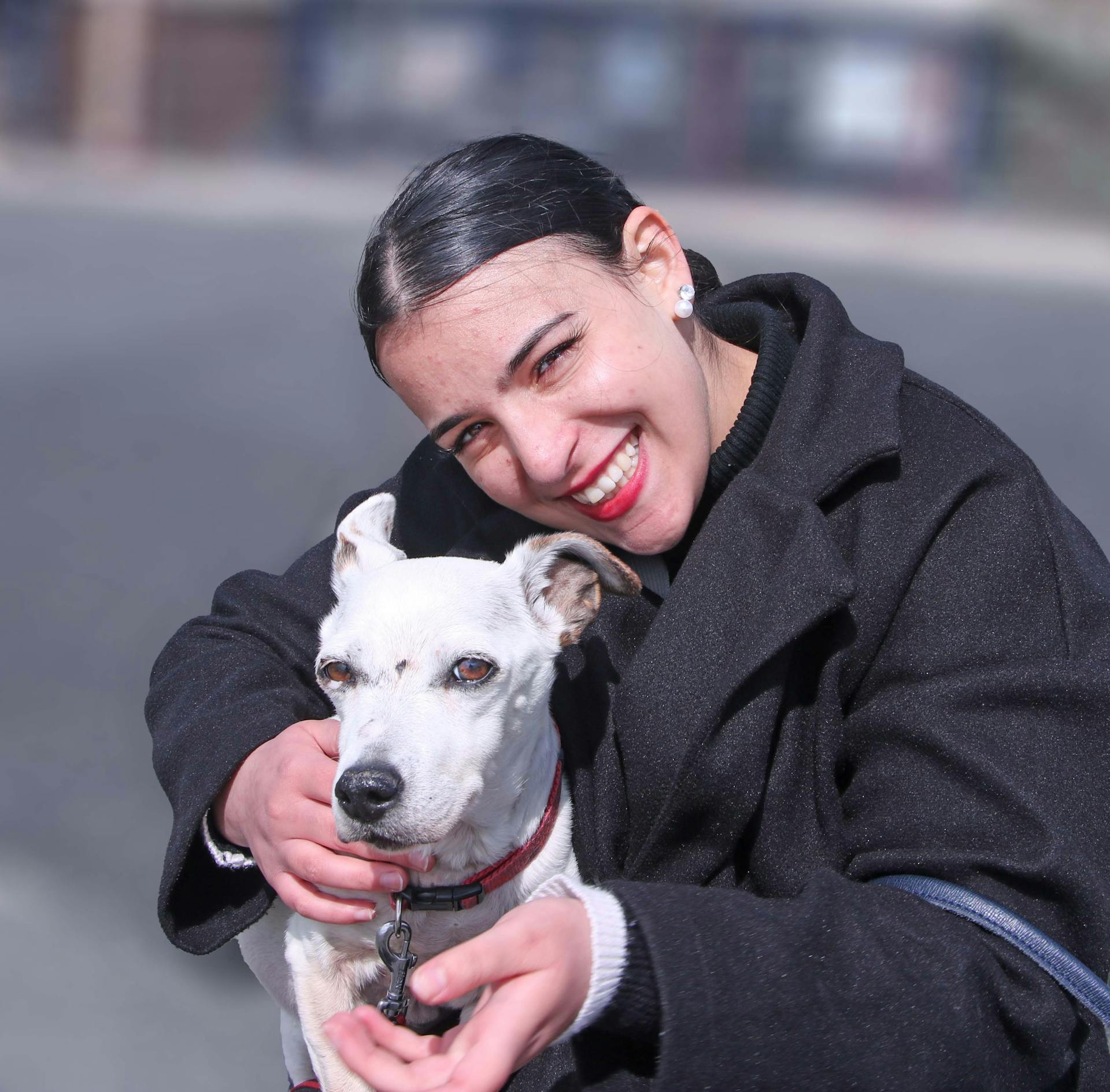 Portret van een lachende vrouw met een witte hond