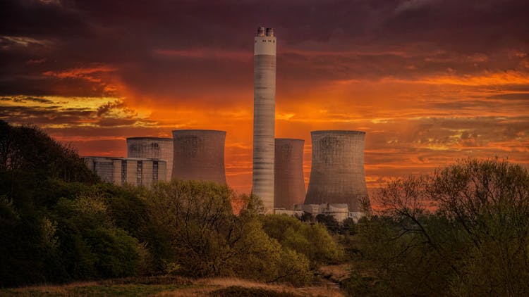 White Nuclear Plant Silo Under Orange Sky At Sunset