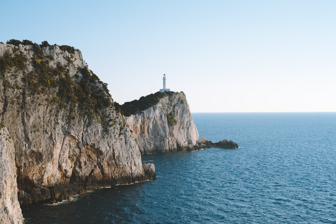 Faro Blanco En La Cima Del Acantilado En La Playa