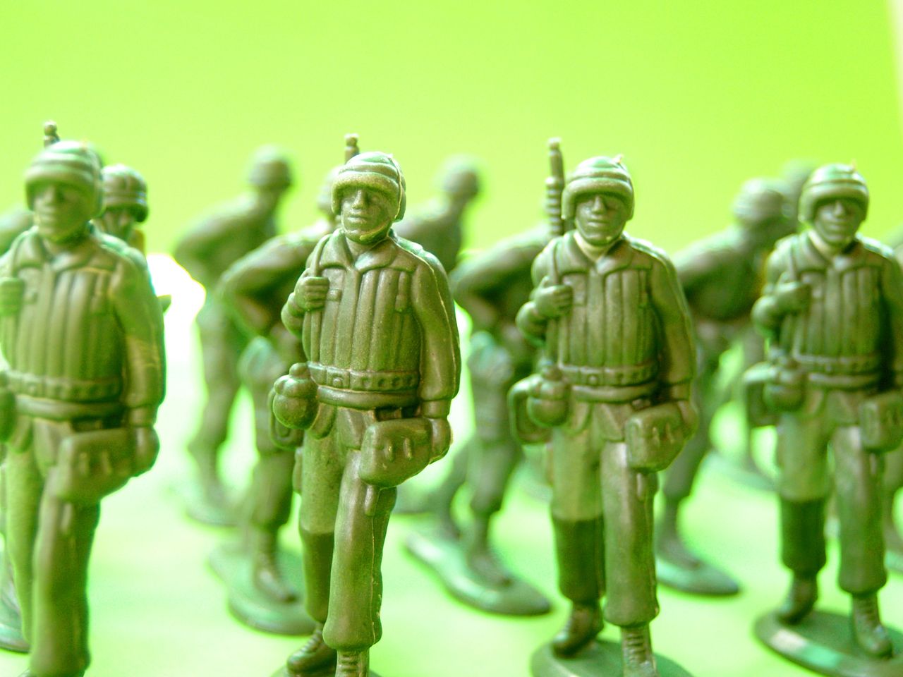 green plastic toy soldiers arranged for strategic play on a vibrant ba
