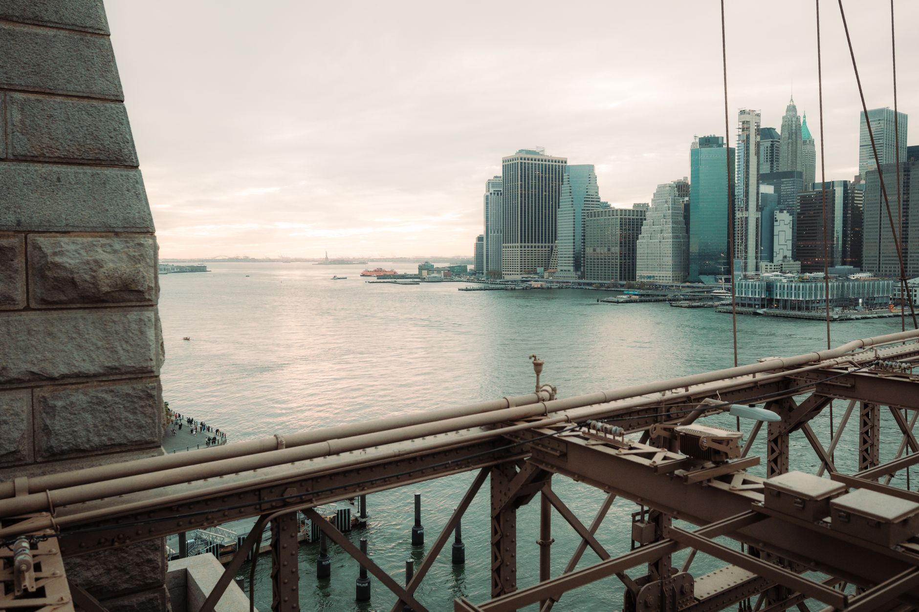 A stunning view of Manhattan's skyline from the Brooklyn Bridge at sunset.