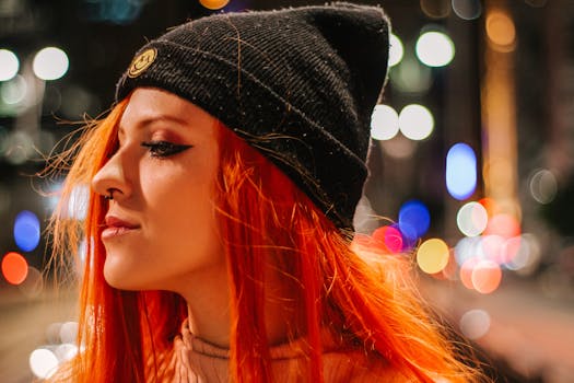 圣保罗的城市灯光下，一位红发鲜艳、头戴黑色无檐帽的女性肖像格外引人注目