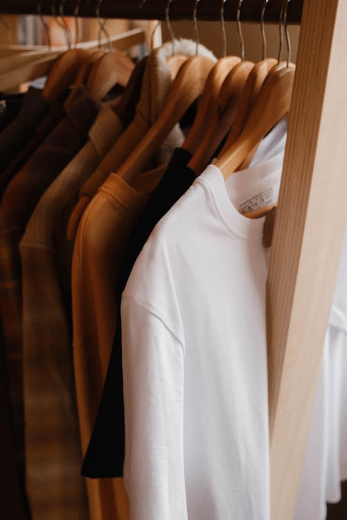 A rack of clothes with white shirts and black pants