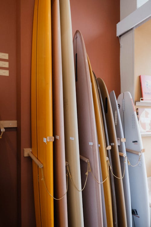 A row of surfboards are lined up in a room