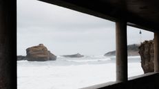 Scenic view of Biarritz Lighthouse through a frame with rocky ocean waves.