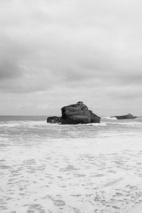 Black and white photo of a rock in the ocean