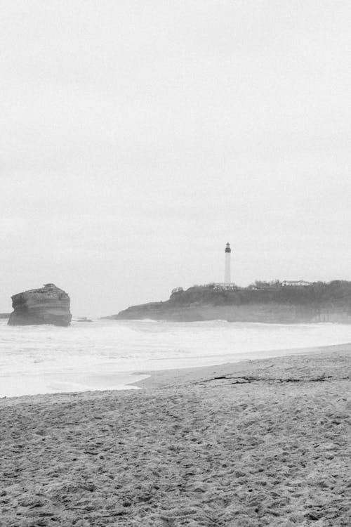 Black and white photo of a lighthouse on the beach