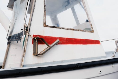 A close up of a boat with a red and white stripe