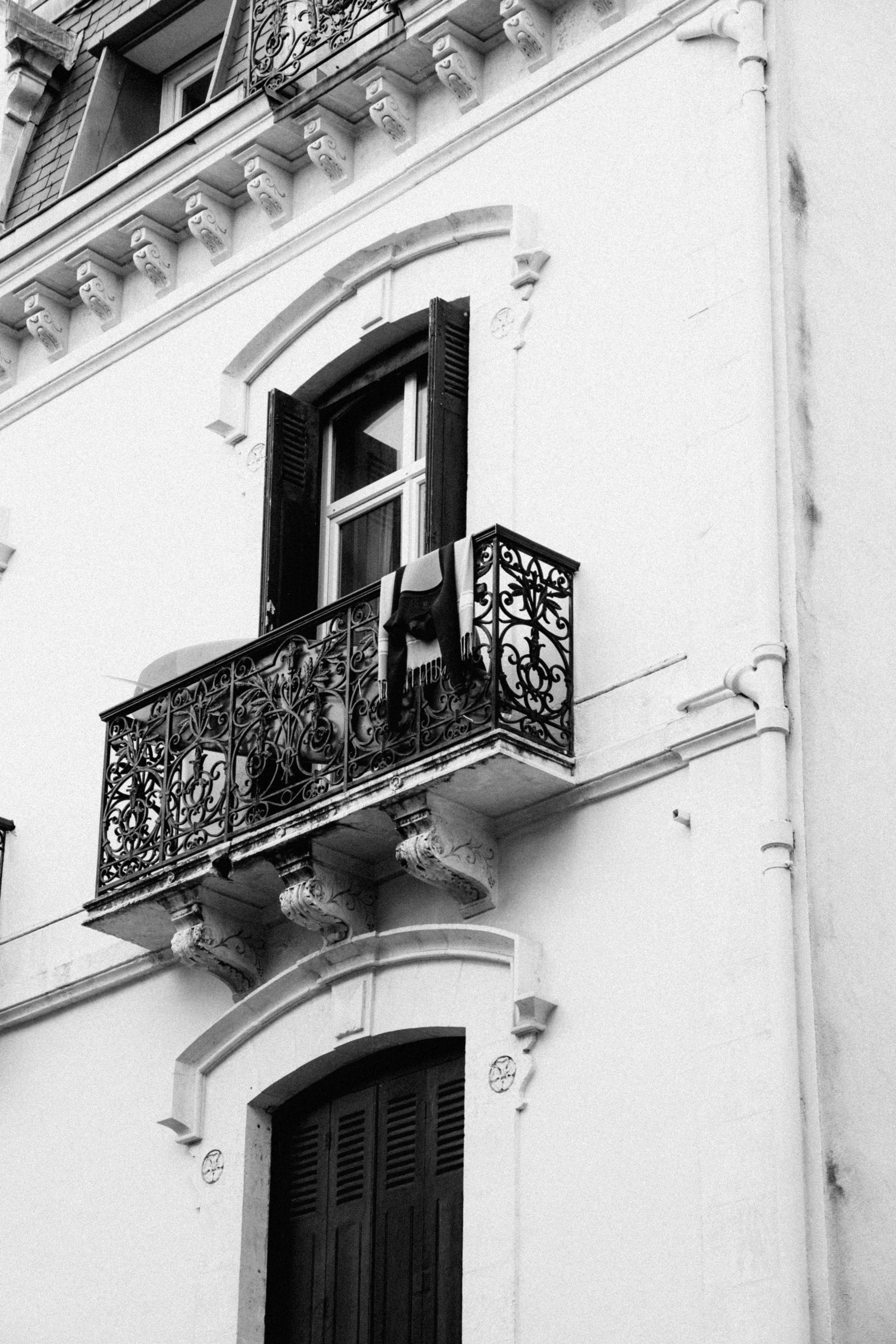Black and white photo of an ornate balcony and facade in Biarritz, France.