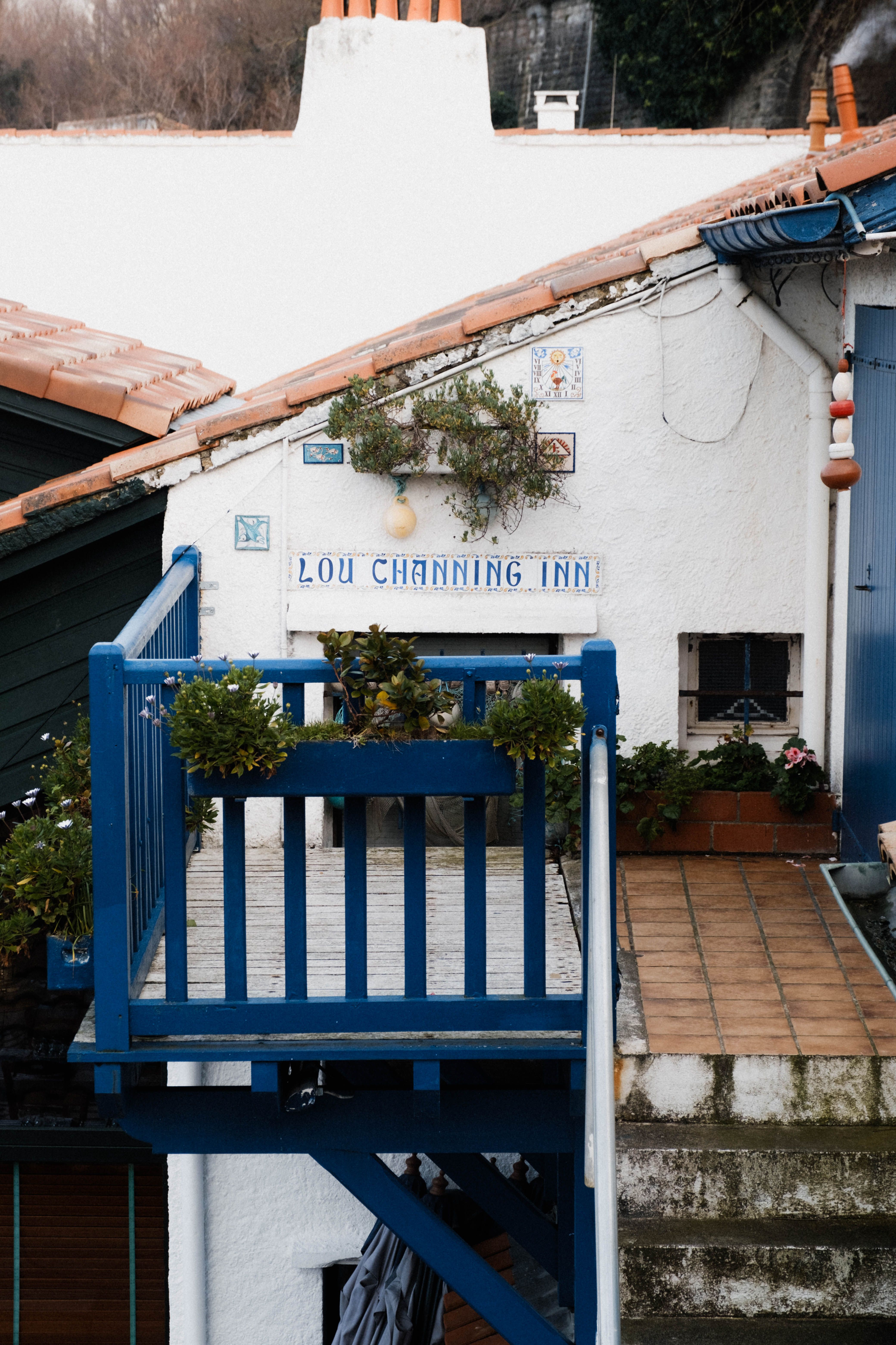 Cozy inn balcony with blue railings in Biarritz, France, showcasing picturesque architecture.