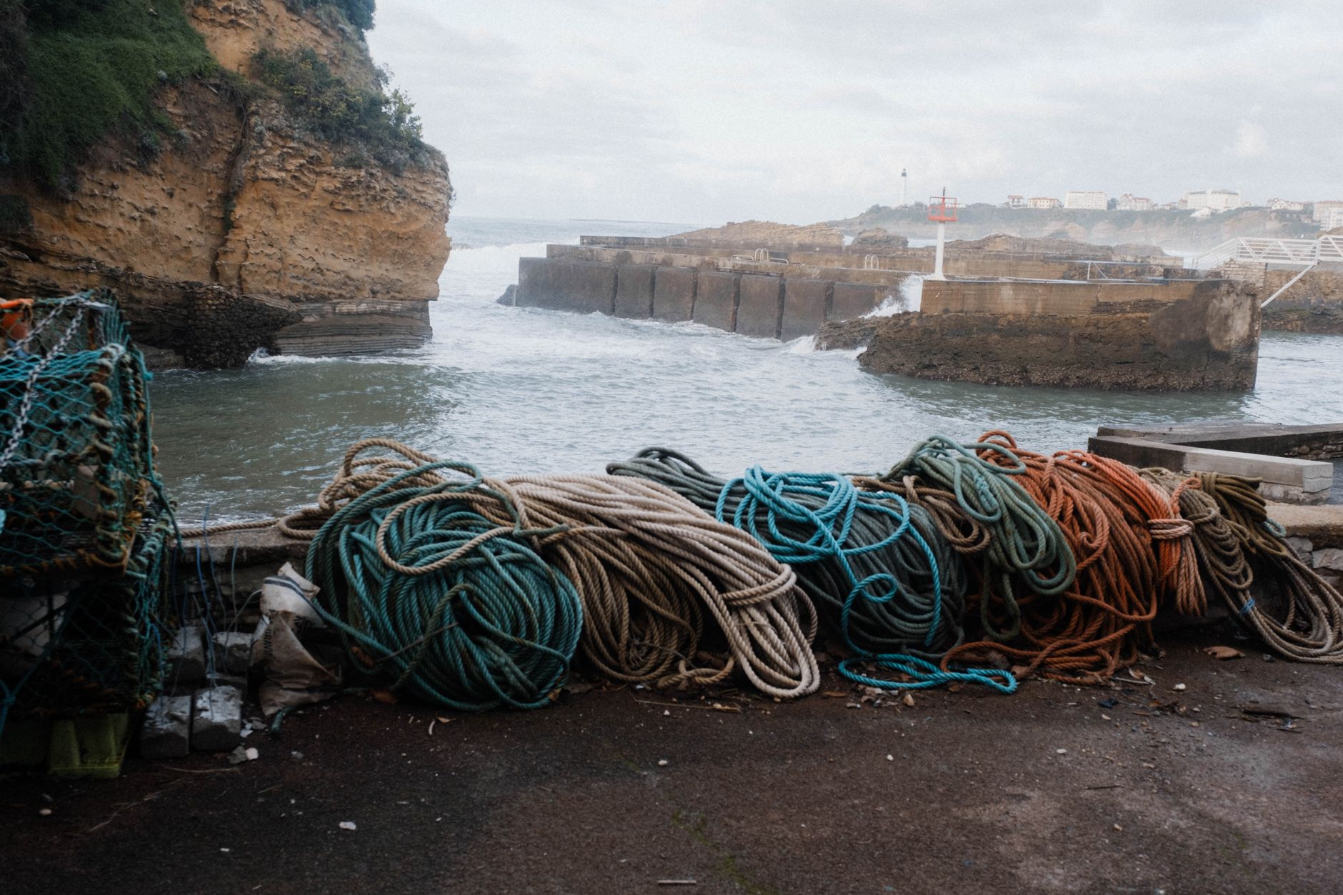 Scenic view of Biarritz marina with coiled ropes and rocky cliffs in France.