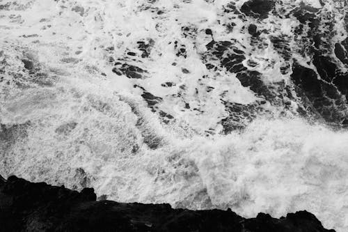 Black and white photo of waves crashing on the shore