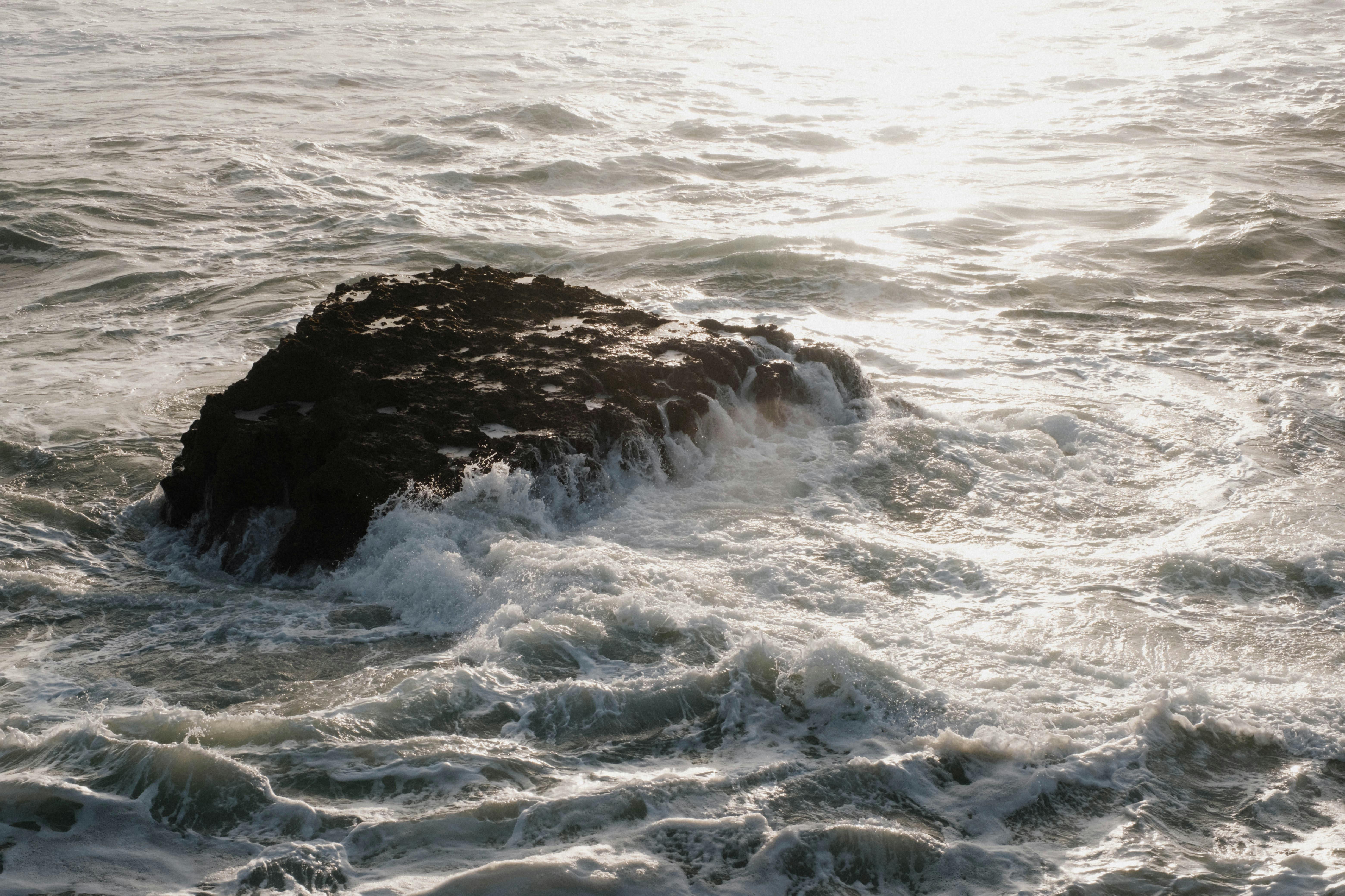 Waves crash on a rugged rock off the coast of Biarritz, France, capturing the ocean's powerful surge.