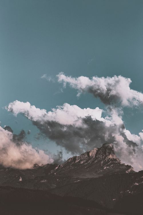 Free A breathtaking mountain peak under a dynamic cloudy sky, showcasing natural beauty. Stock Photo