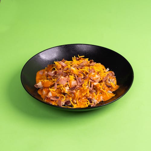 A bowl of food with cheese and meat on top