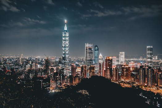 Night view of the Taipei skyline featuring the illuminated Taipei 101 amid modern skyscrapers.