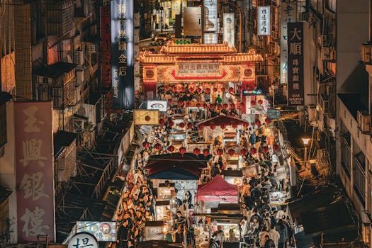 Bustling night market scene at Raohe Street, Taipei, showcasing vibrant street life and illuminated stalls.