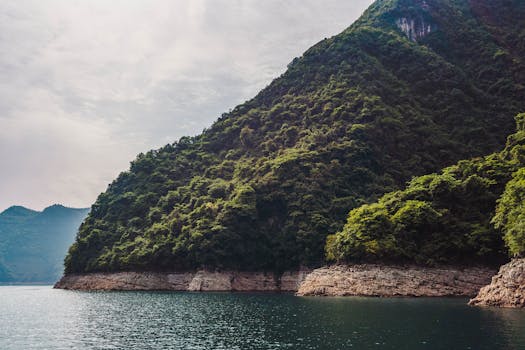 Spectacular view of lush green mountains meeting the tranquil waters of Yichang's coast in Hubei, China.