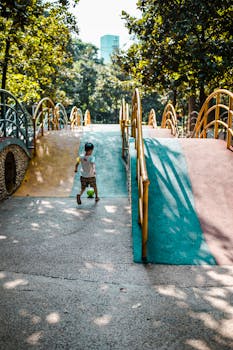 阳光明媚的武汉公园里，一个小男孩在充满活力的操场上玩球