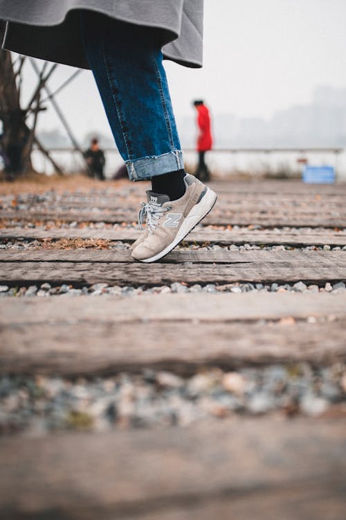Selective Focus Photo of Person Standing on Wooden Planks 