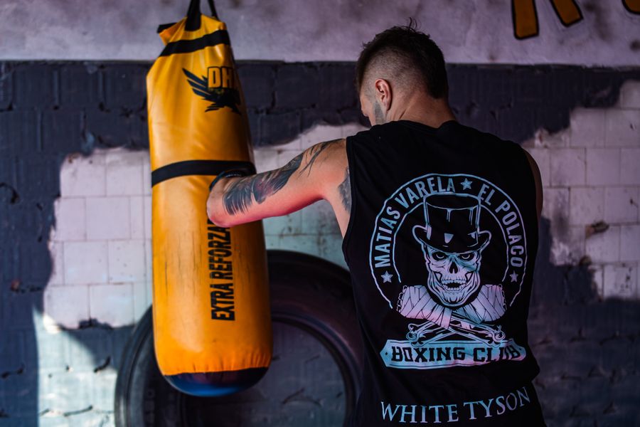 Boxer training with a punching bag in an indoor gym
